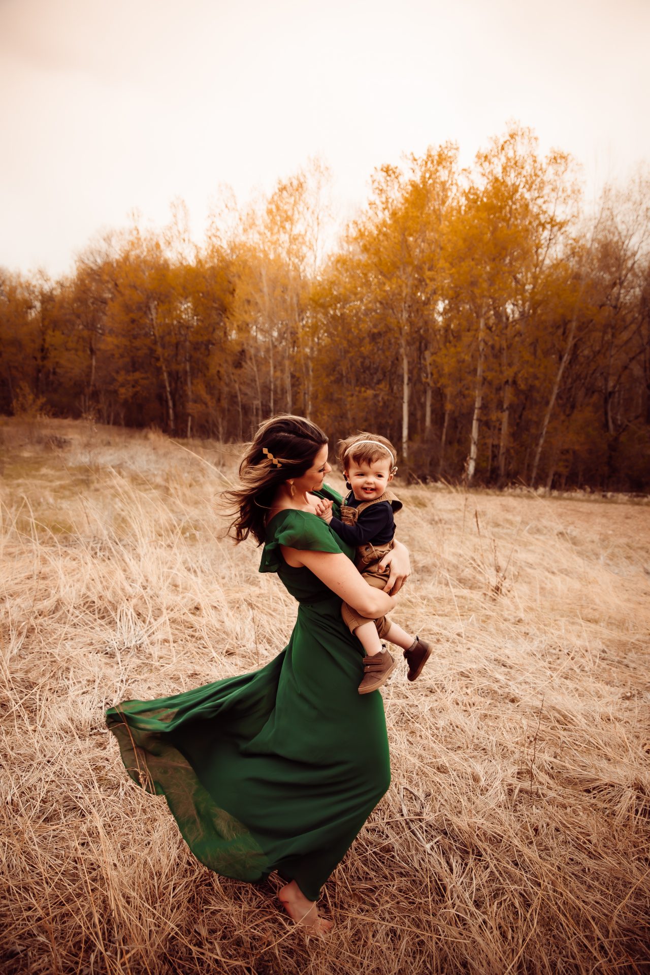 A joyful moment captured in the warm glow of sunset—mother and child, raising a deaf child, sharing a tender embrace amidst a rustic autumnal landscape that celebrates inclusion.